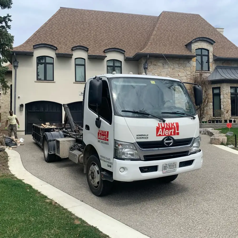 Junk Alert crew loading a truck in a residential driveway