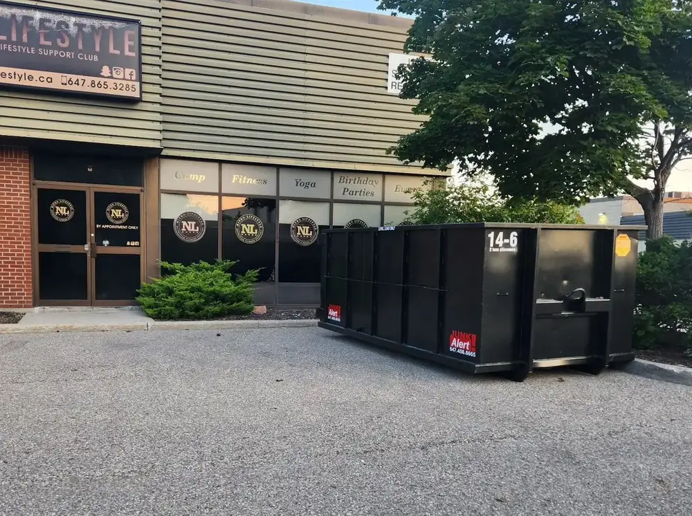 Fourteen yard bin outside a commercial storefront