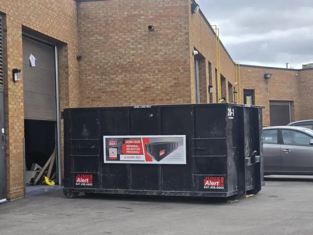 Bin in a commercial lot beside a brick building