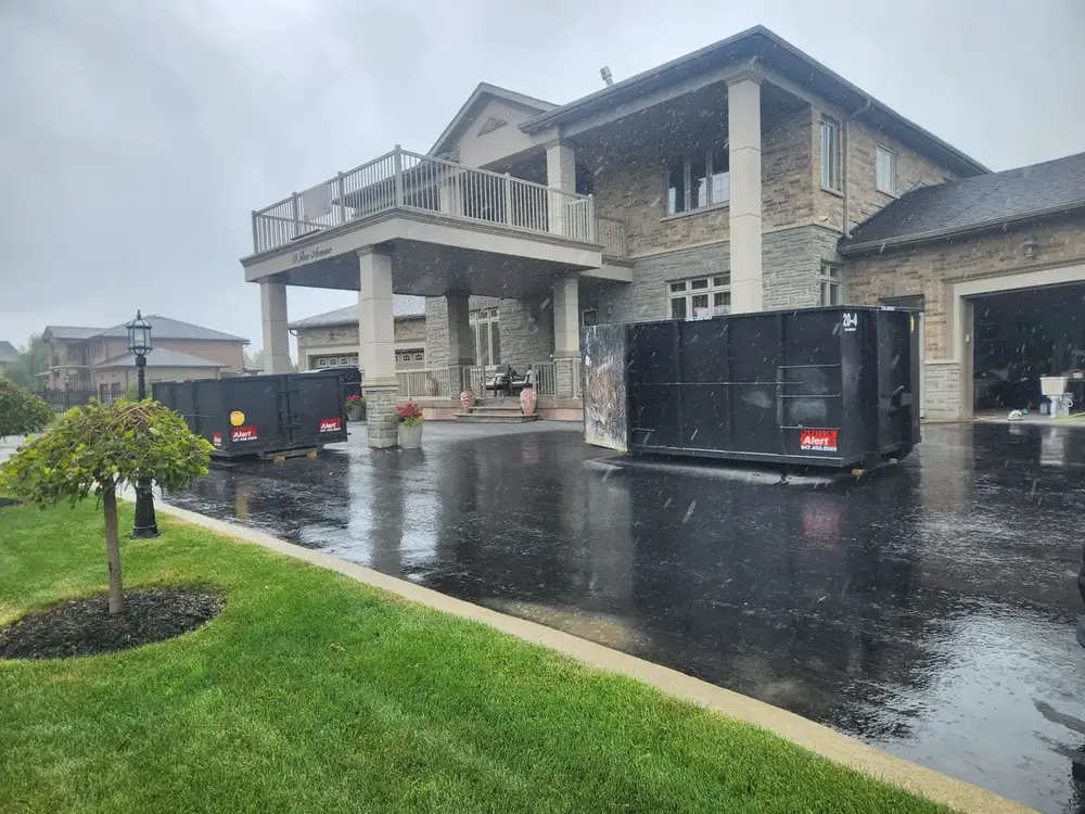 Two bins dropped on a wet driveway at a large home