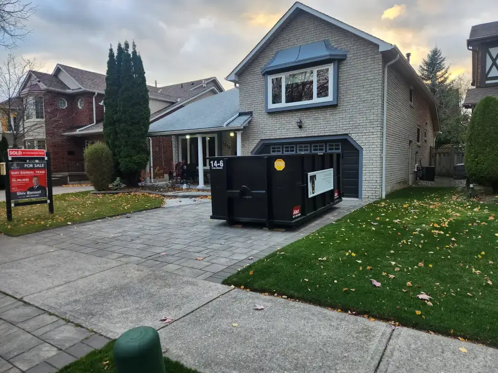 Bin on a driveway in front of a two-storey home