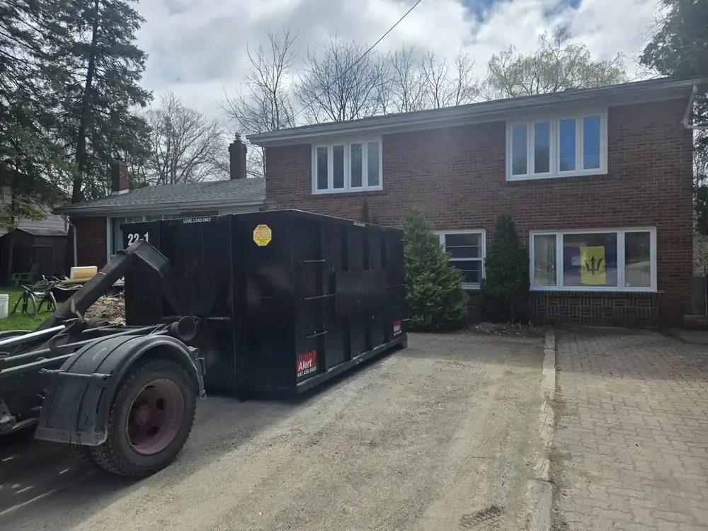 Truck dropping a bin at a brick home