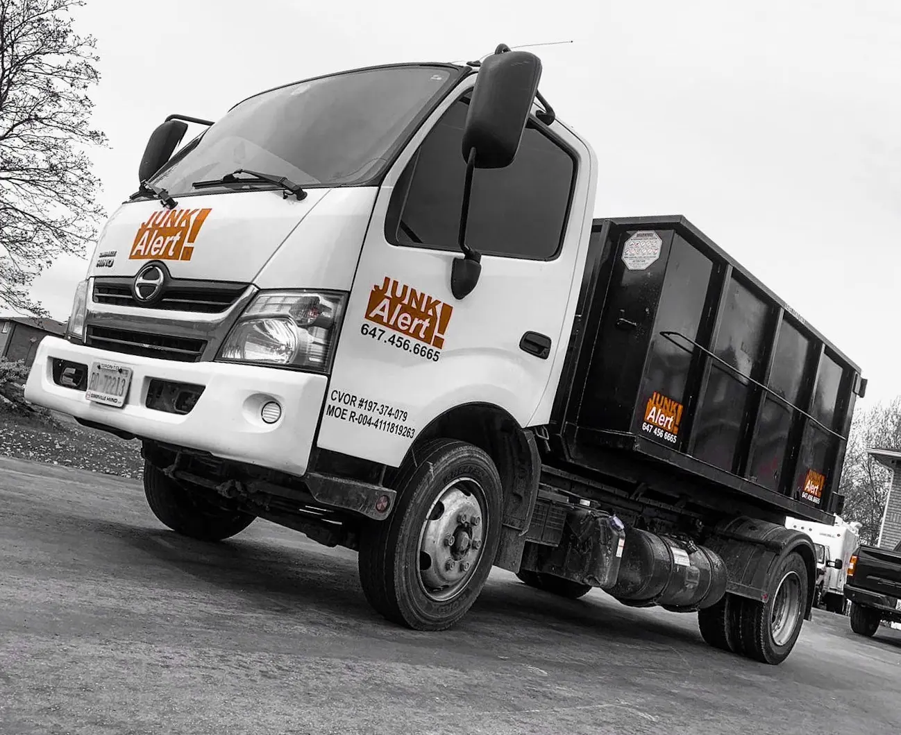 Junk Alert roll-off truck with a bin loaded